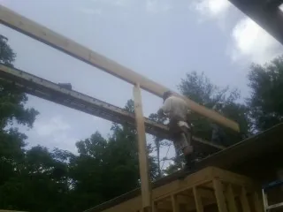 Carpenter setting a ridge beam over a new addition frame — Ice Dam Removal by Roofing Brothers in Forest Park