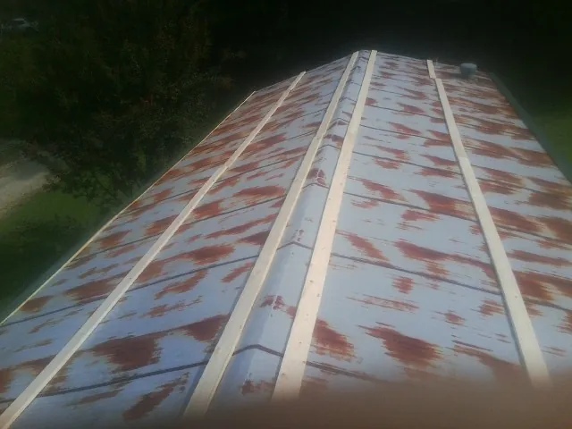 Rusted metal roof panels with new wood purlins before replacement — Storm Damage Roof Repair in Forest Park by Roofing Brothers